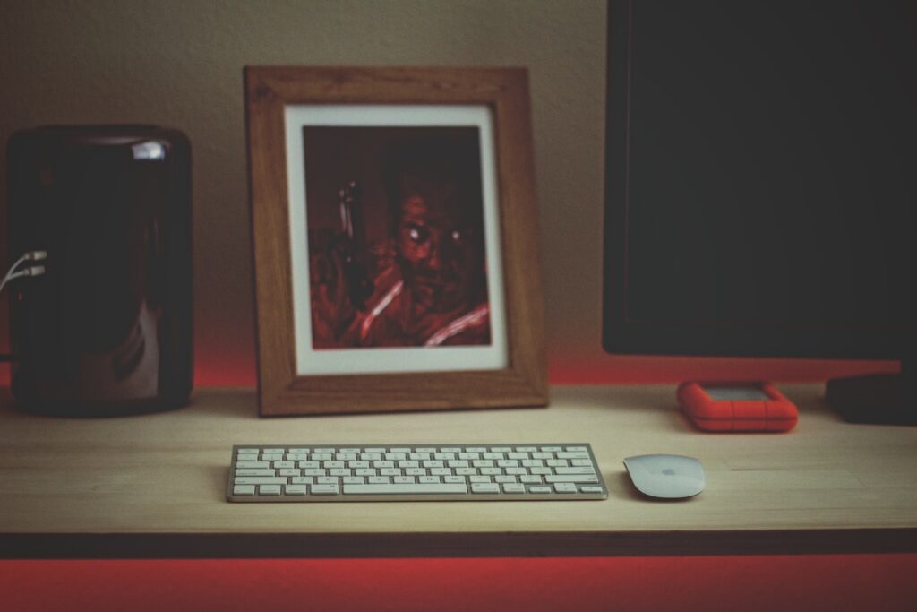 Tabletop view of workspace in home office with fine art print and desktop computer.