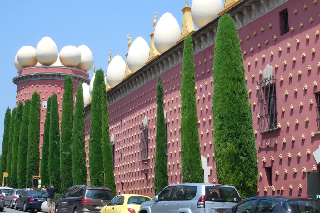 a row of trees line the side of a building